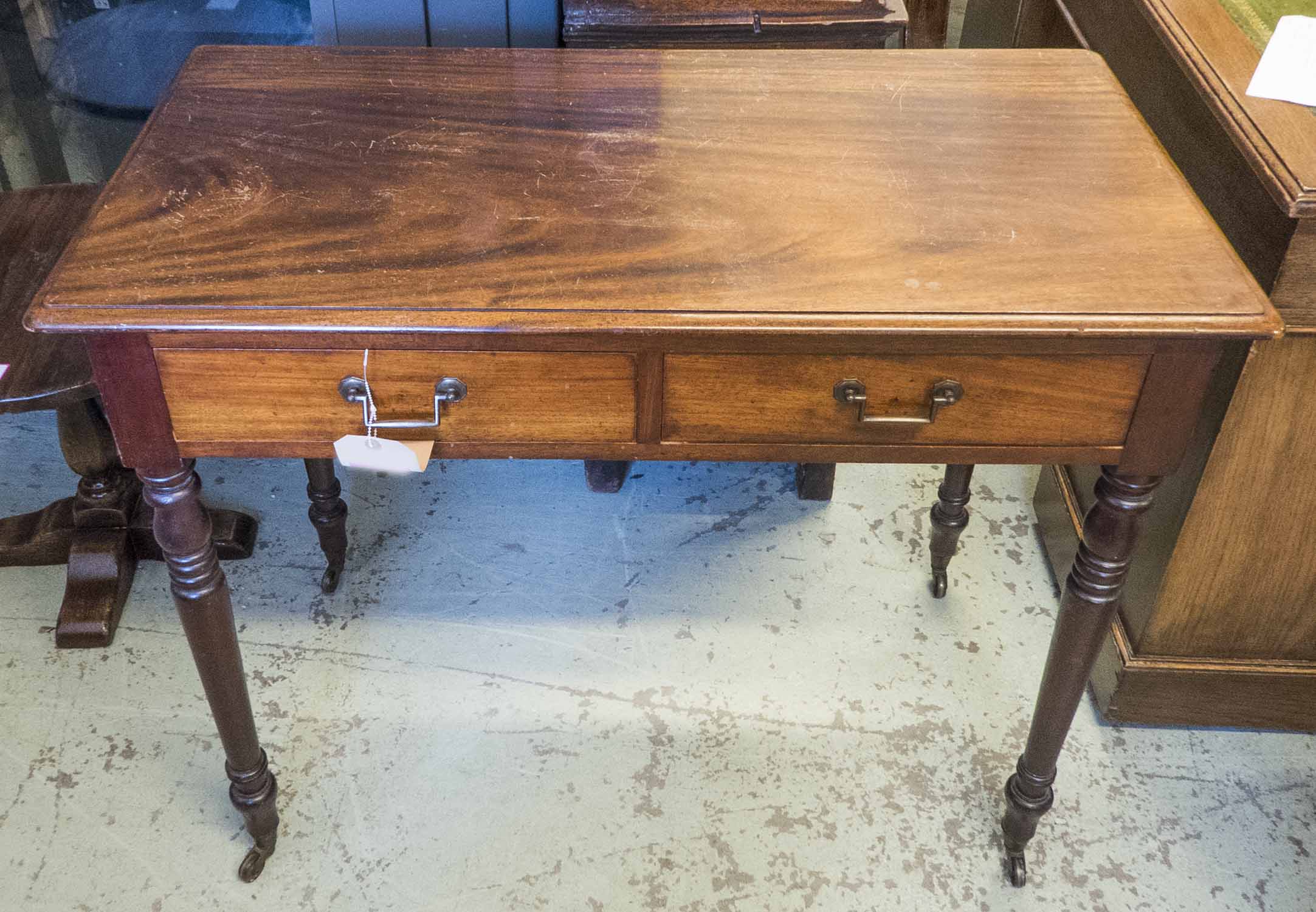 WRITING TABLE, Victorian mahogany with two frieze drawers on turned supports with castors,