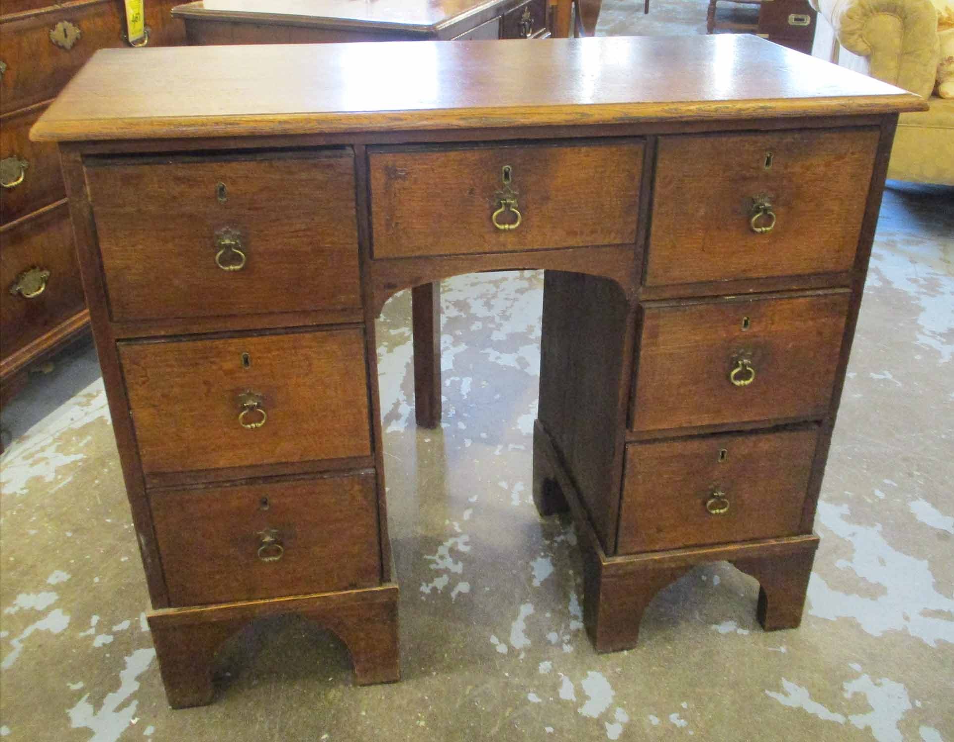 KNEEHOLE DESK, George III oak with seven short drawers below, 96cm W x 79cm H x 39cm D.