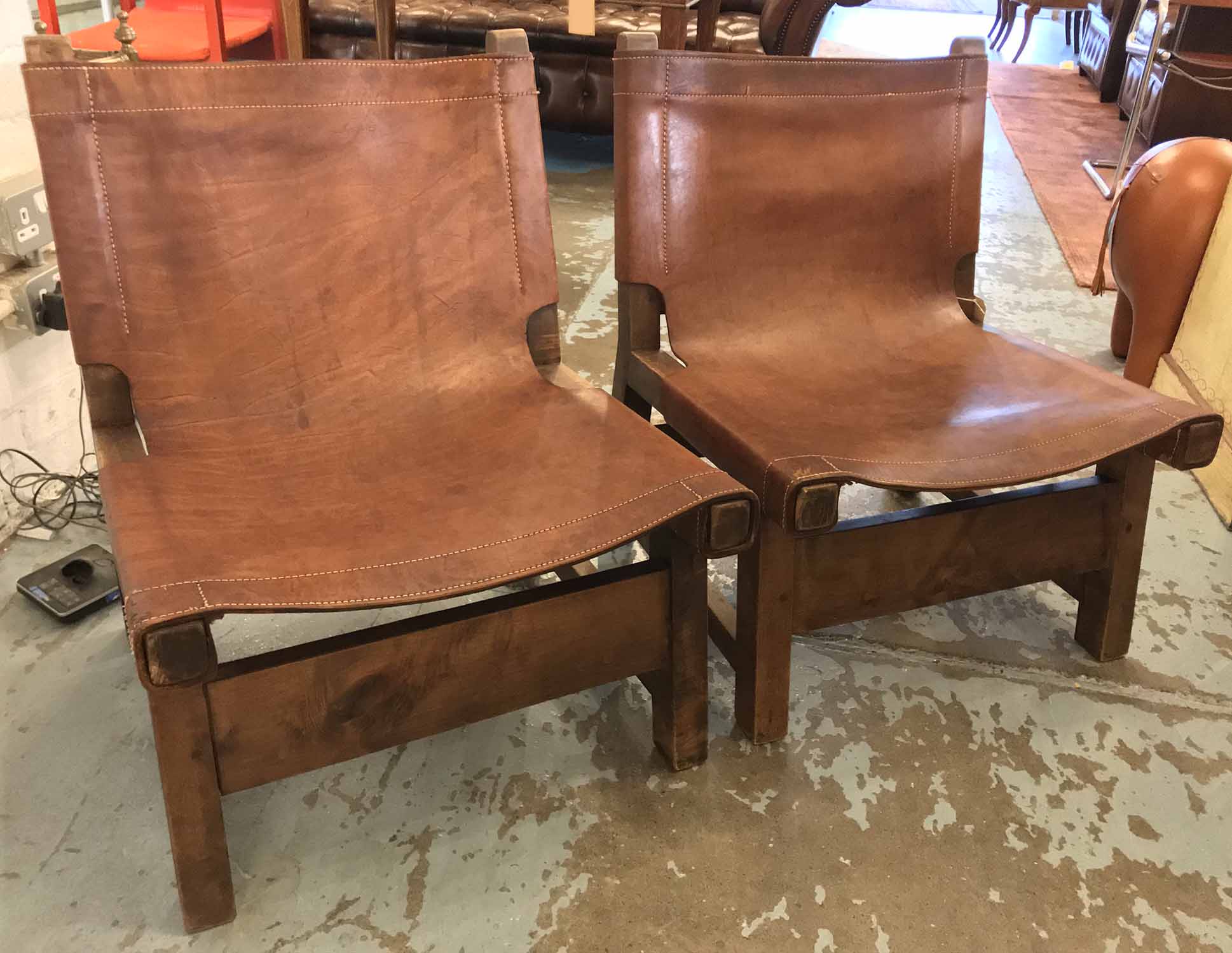 SLING CHAIRS, a pair, ranch style, stitched raw coach hide leather and belted 57cm W.