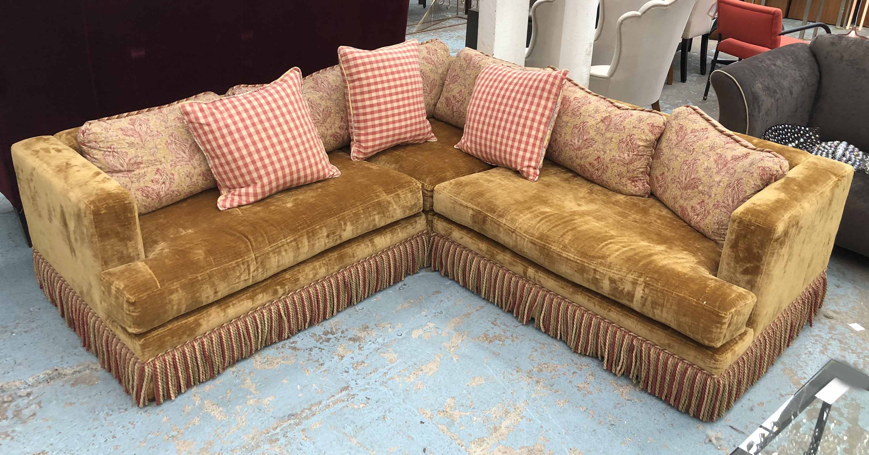 CORNER SOFA, mustard velvet with polychrome bullion fringe and nine patterned loose cushions,