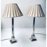 COLUMN LAMPS, a pair, each with tall graduated silvered metal column and shade.