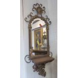 METAL SWIRLED WALL MIRROR, with a bevelled plate, gilt detail and shelf, 107cm H x 44cm W.