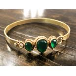 BANGLE, unmarked yellow metal with three pear shaped green stones.