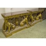 CONSOLE TABLES, a pair, gilt framed with glass and red lacquered tops on twin sphynx supports,