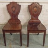 HALL CHAIRS, a pair, 19th century mahogany with shield backs.