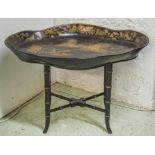 TRAY TABLE, black and gilt papier mache of shaped oval form with Chinoiserie decoration,