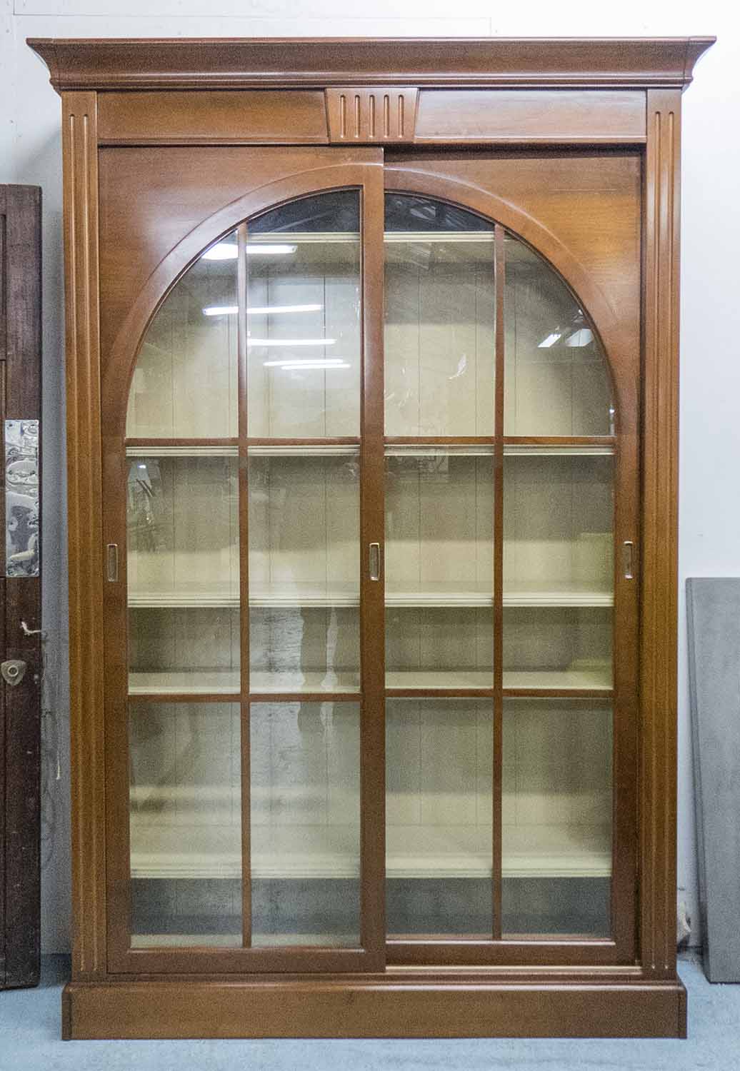 GRANGE BOOKCASE, 'Stendhal' with two sliding glazed arched doors enclosing shelves on a plinth base,