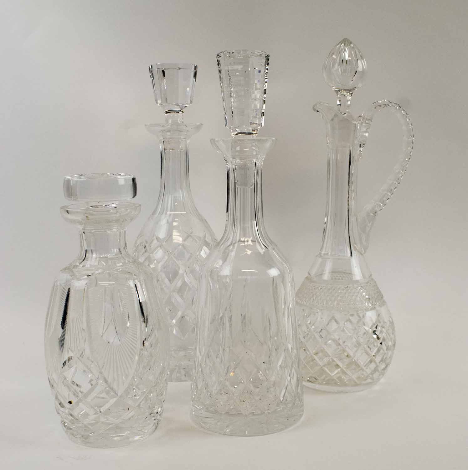 FOUR VARIOUS WATERFORD DECANTERS/CLARET JUGS.