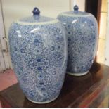 JARS WITH COVERS, a pair, Chinese style blue and white of ovoid form with foliate decoration,