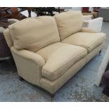 SOFA, two seater, Howard style in beige fabric on turned castor supports, 189cm L.