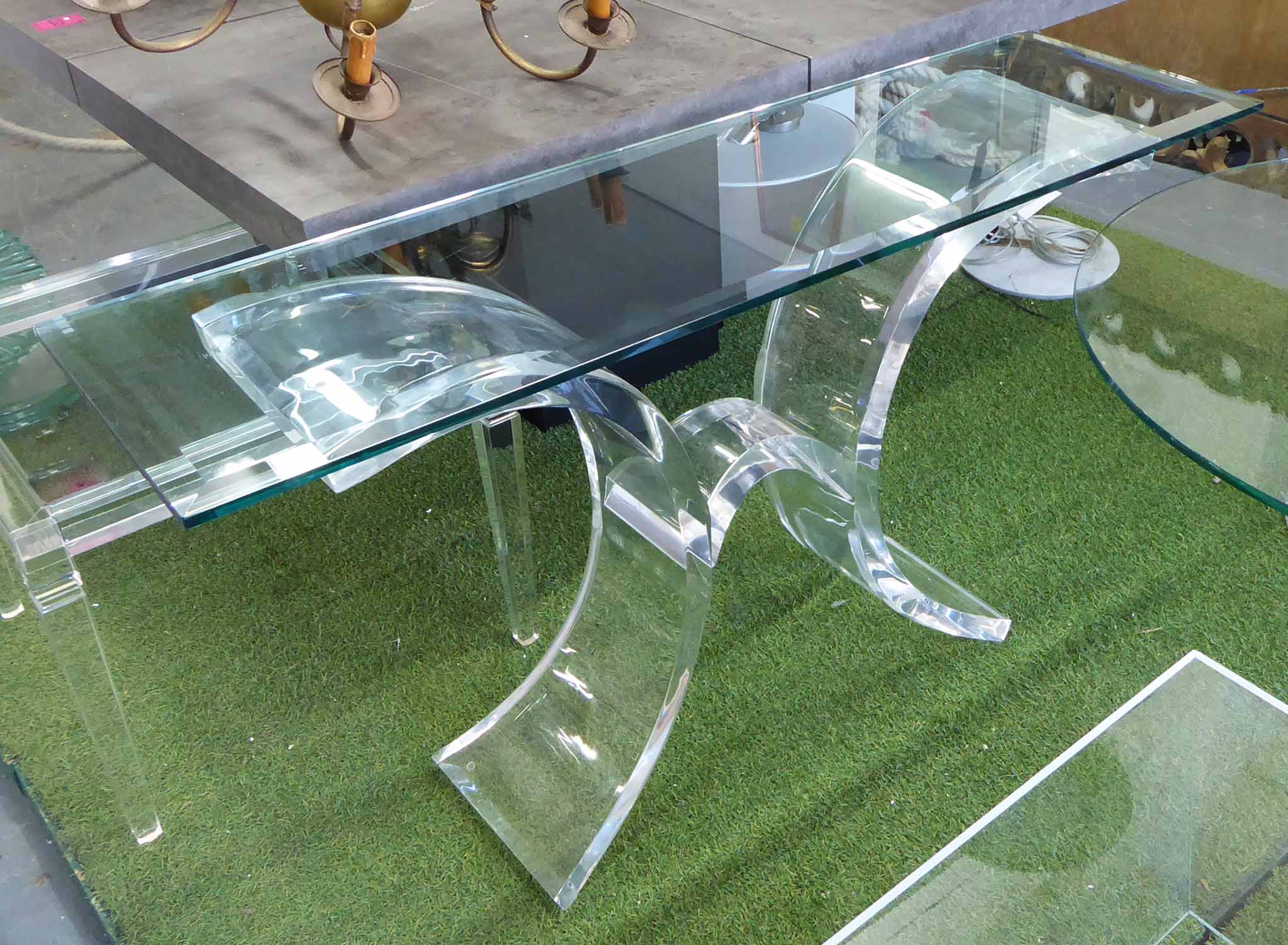 CONSOLE TABLE, with glass top on a curved lucite base in the style of lion in frost,