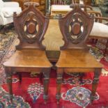 HALL CHAIRS, a pair, Victorian mahogany with cabochon centred shield backs.