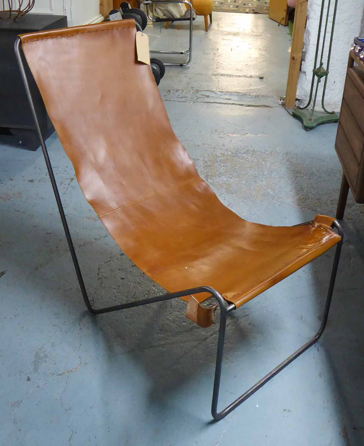 LEATHER SLING CHAIR, on hair pin frame, 94cm H x 110cm D x 57cm W.