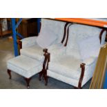 A PAIR OF MODERN WOODEN FRAMED WING BACK FIRESIDE ARM CHAIRS WITH MATCHING FOOT STOOL