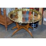 AN EASTERN STYLE BRASS TOP FOLDING OCCASIONAL TABLE