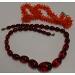 19½" STRING OF VINTAGE CHERRY AMBER COLOURED BEADS, TOGETHER WITH A CORAL EFFECT NECKLACE