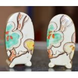 A PAIR OF ART DECO HAND PAINTED SALT & PEPPER CRUETS IN THE STYLE OF CLARICE CLIFF