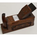 A WORLD WAR 1 TRENCH ART CARVED OAK MONEY BANK IN THE FORM OF A WOOD PLANE