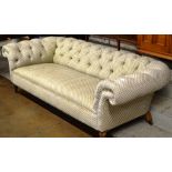 4 SEATER CHESTERFIELD STYLE FABRIC UPHOLSTERED SETTEE ON MAHOGANY LEGS WITH BRASS CASTORS