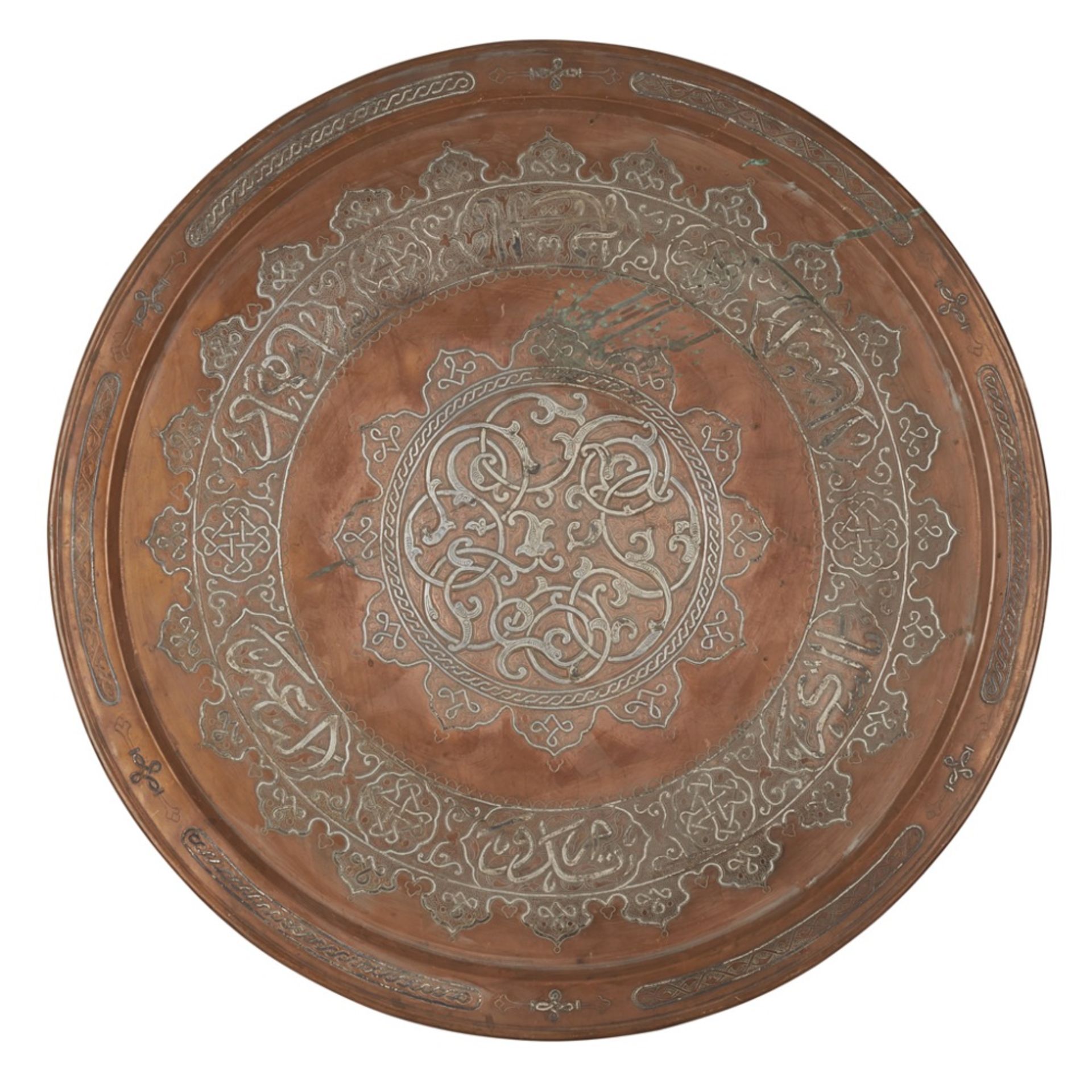 ISLAMIC WHITE METAL INLAID COPPER CHARGER/TRAYwith flattened rim, enclosing a central medallion