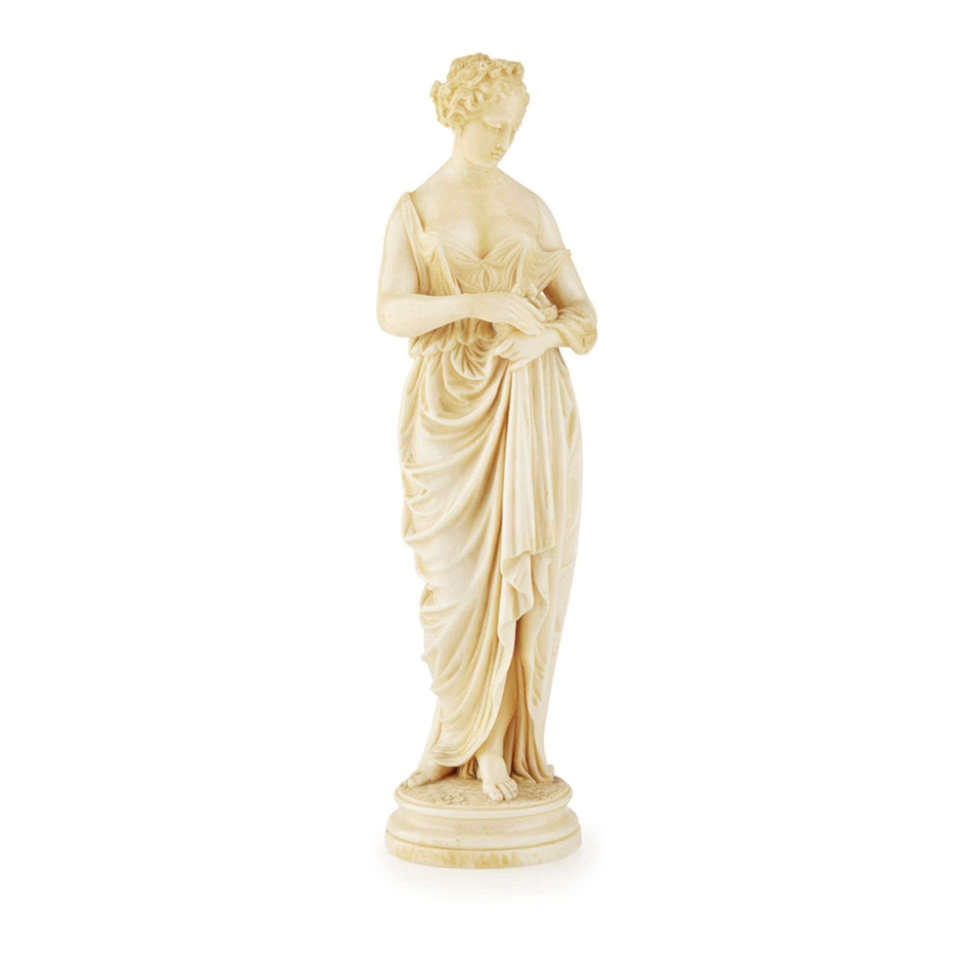 FRENCH CARVED IVORY FIGURE19TH CENTURY depicting a woman in Classical costume holding a nest of