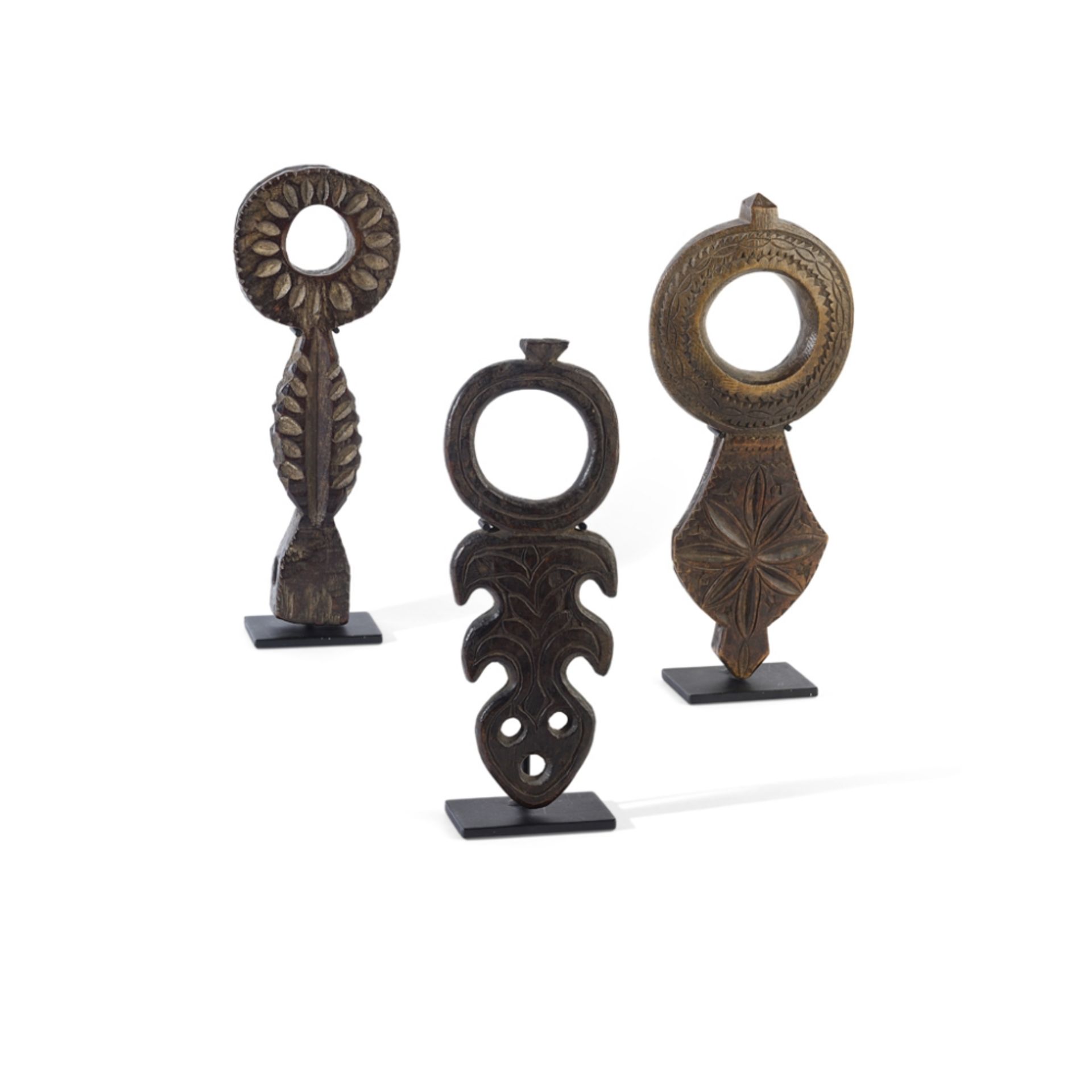 THREE NEPALESE BUTTER CHURN HANDLES, GHURRANEPAL, EARLY 20TH CENTURY carved wood, all raised on a