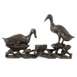 PAIR OF BRONZE GEESEMING DYNASTY the birds supported on an elaborately carved wooden stand depicting