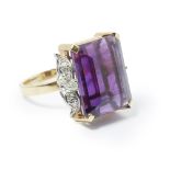 An amethyst set cocktail ring claw set with a large rectangular cut amethyst, each shoulder set with