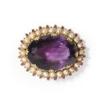 A large amethyst and pearl set brooch claw set with a large oval mixed cut amethyst, in a border