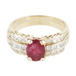 A ruby and diamond set ring claw set with an oval cut ruby, each shoulder set with small round and