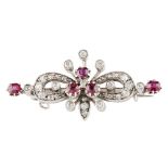 An Edwardian ruby and diamond set brooch of symmetrical form, claw set with a central group of three
