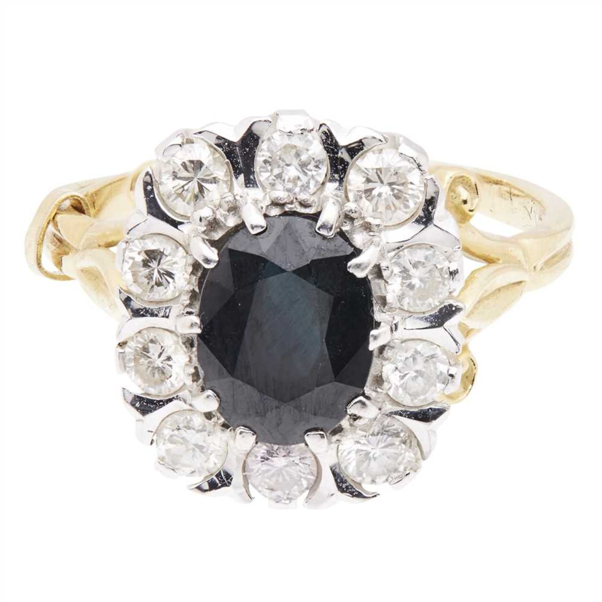 A sapphire and diamond set cluster ring claw set with an oval cut sapphire, in a border of round