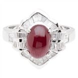 A ruby and diamond set cluster ring claw set with an oval ruby cabochon, in a ballerina style border