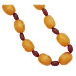 An amber bead necklace composed of fifteen amber beads, between red bead spacers . (Dimensions: