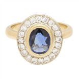 A sapphire and diamond set cluster ring collet set with an oval cut sapphire, in a single border