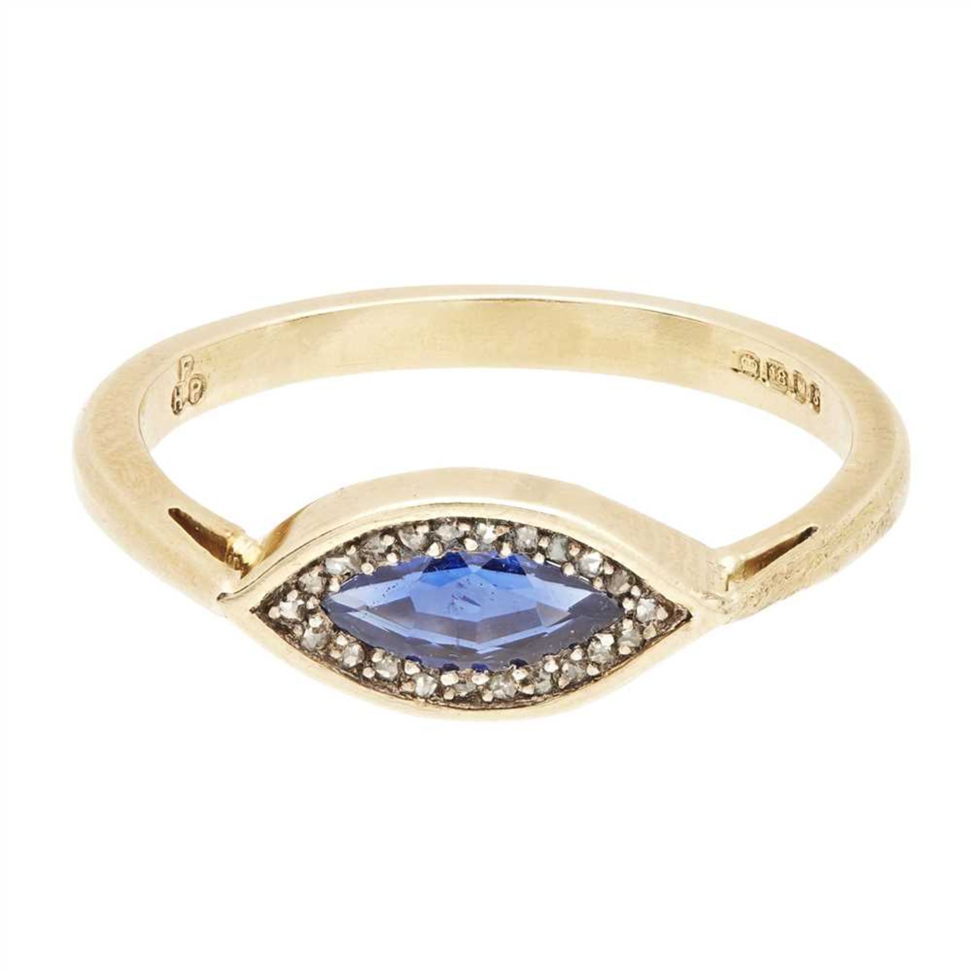 A sapphire and diamond set ring millegrain set with a marquise shaped blue sapphire, in a border