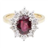 A ruby and diamond cluster ring claw set with an oval cut ruby in a border of small round