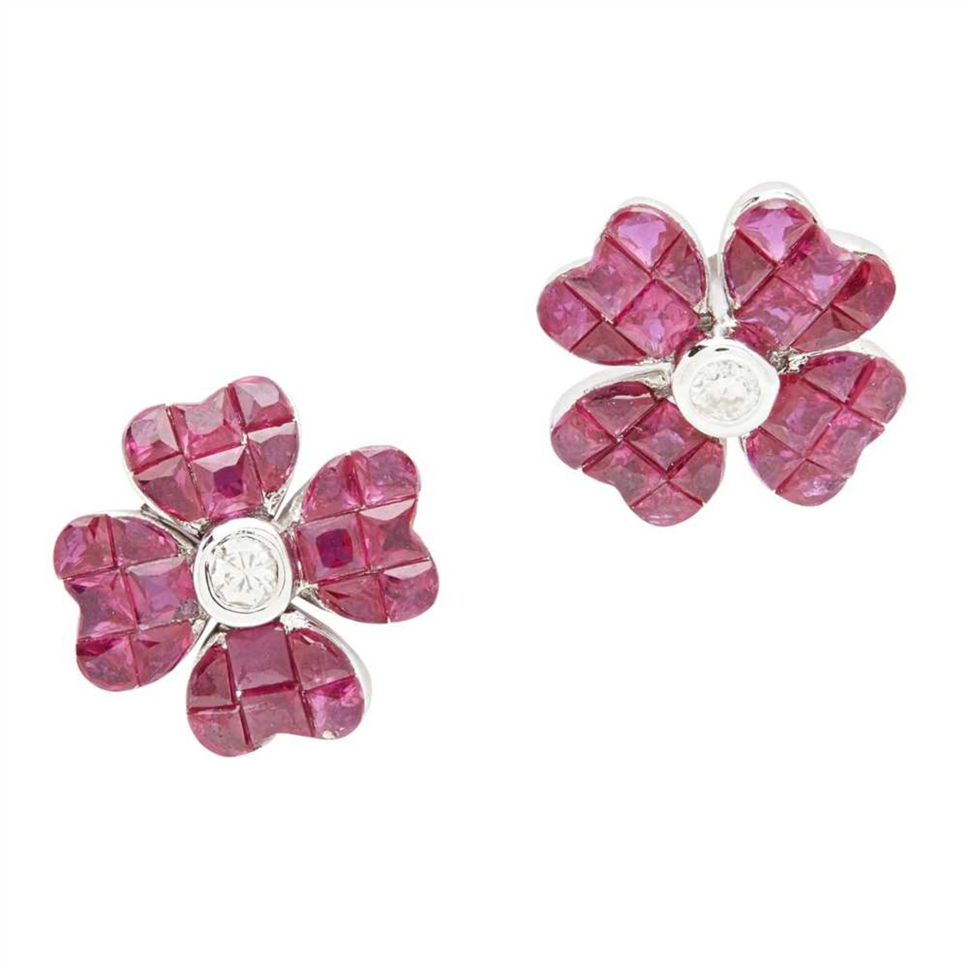 A pair of ruby and diamond set floral earrings each modelled as a flower, collet set with a round