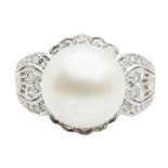 A South Sea pearl and diamond cocktail ring set with a large South Sea pearl, in a border of small