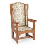 GOODYERS, LONDON ARTS & CRAFTS OAK FRAMED WINGED ARMCHAIR, CIRCA 1910 with later-upholstered back