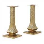 GLASGOW SCHOOL PAIR OF ARTS & CRAFTS BRASS CANDLESTICKS, CIRCA 1900 with square sconces above