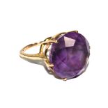 A gold colour metal ring set with amethyst colour stone