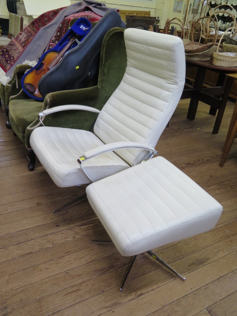 A 1970s cream leather and chrome lounge armchair and a matching footstool