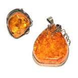 A large amber ring set in silver and a matching pendant