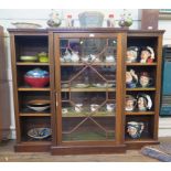 A mahogany breakfront bookcase, the dentil cornice over an astragal glazed door flanked by open