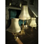 A pair of turned brass table lamps and a carved giltwood table lamp