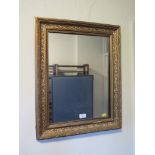 A Victorian giltwood picture frame, with oval aperture, now fitted with a mirror, 64cm x 54cm and