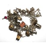 A silver charm bracelet with many charms and a chrome cigarette case