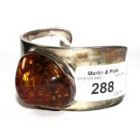 An continental amber bangle set in silver colour metal