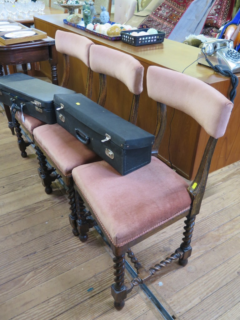 Three late Victorian oak dining chairs, the upholstered top rails and seats on barleytwist and block